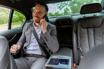 Professional businessman enjoying a conversation on his smartphone during a comfortable car ride