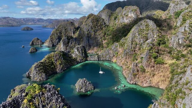 The Aerial view of white sand beach bathed by a crystal clear water. Entalula island, Bacuit Bay, El Nido, Palawan, Philippines.	