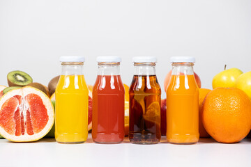 Different types of fruit juices - orange, grapefruit, apple and multifruit in glass bottles.