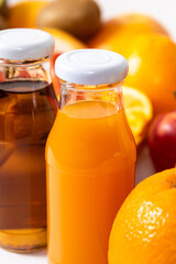 Close-up of orange and apple juice in glass bottles