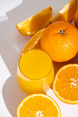 Orange juice in a glass among fresh oranges top view