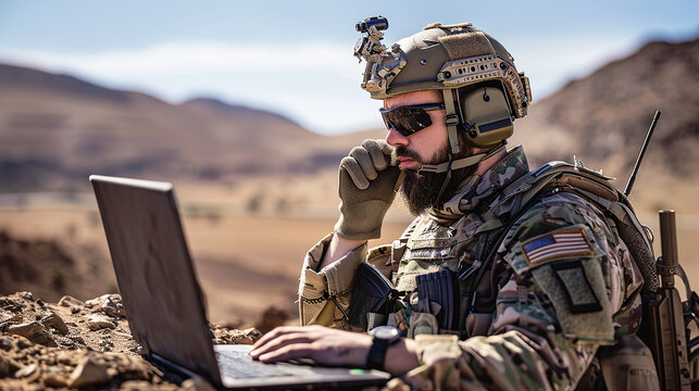 The soldier communicates during military operations in the desert using his laptop computer and radio