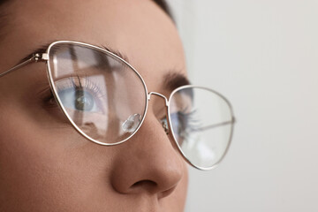 Woman wearing glasses on blurred background, closeup