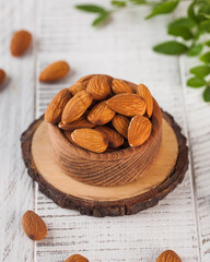 Organic raw almonds in a rustic wooden bowl, perfect for a healthy and nutritious snack