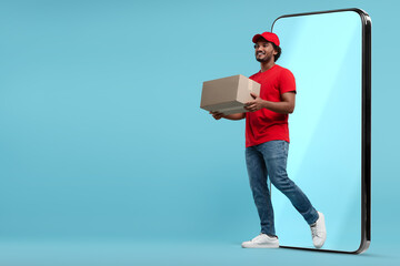 Courier with parcel walking out from huge smartphone on light blue background. Delivery service....