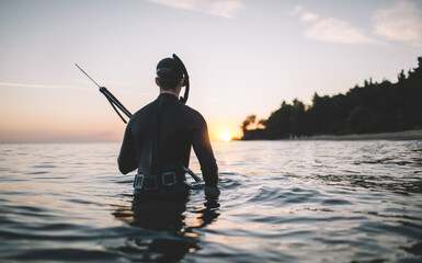 Rear view of spearfisherman watch the sunset