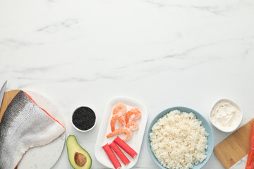 Making sushi rolls. Flat lay composition with ingredients on white marble table. Space for text