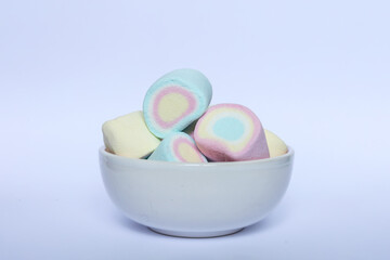 Fototapeta premium Colorful marshmallows in a bowl on a white background.