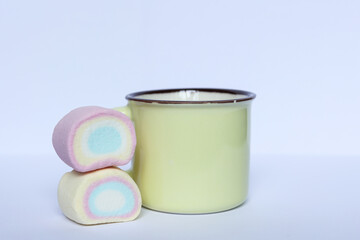 pastel color cup and marshmallows on white background	