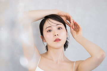 Naklejka premium 白いドレスを着た美しいアンニュイな表情の女性 美容・ビューティー美しい綺麗なイメージ 美白や艶、スキンケアのカメラ目線