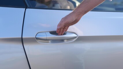Male hand opening the car door. Passenger seat. Close up. Transport and lifestyle concept. Real time