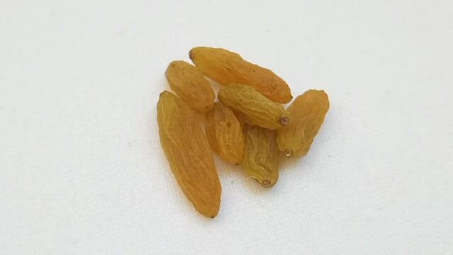 Raisins on a turntable on white background, macro shot, close up dry fruits, raw snack
