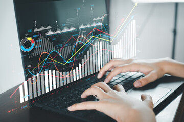 Businesswoman using laptop with financial,business analytics chart and graph interface idea for ...