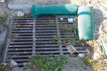 storm water drain on beach with rubbish