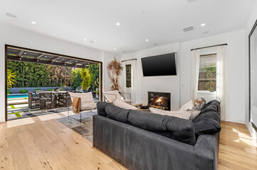living room with fireplace, television and glass doors overlooking backyard
