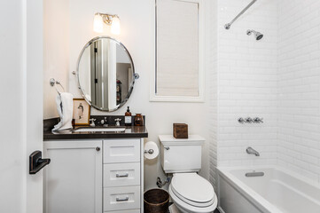 a bathroom with a white tub and toilet in it and a sink and mirror in