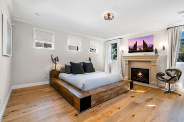 a clean bedroom is shown with hardwood flooring and white walls