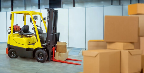 Forklift near cardboard boxes. Storage equipment. Forklift for unloading goods. Storage...