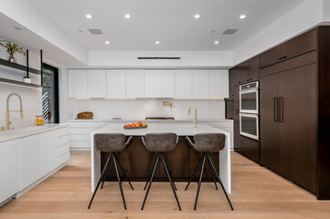 this is a spacious kitchen with two breakfast bar stools