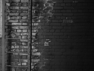 Old black brick wall tetxure. Grunge backgrond. Dark wallpaper
