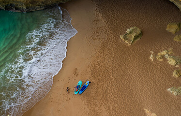Top view one couple with sup boards on sand near blue water of Atlantic ocean of Portugal in...