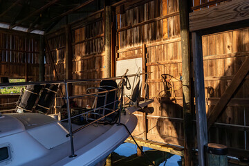 Solomons, Maryland USA A boat is moored inside  a wooden boathouse on the shore of the Patuxent...