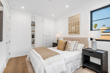 a well decorated bedroom with hardwood floors and white walls, along with white bedding