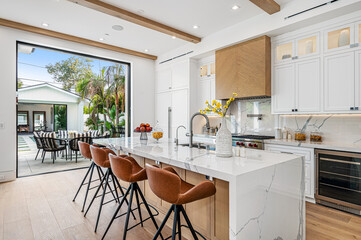 the kitchen is bright and modern in this home design featuring the high - backed bars