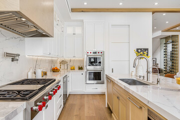a clean kitchen with white cabinets and countertops and wooden floor