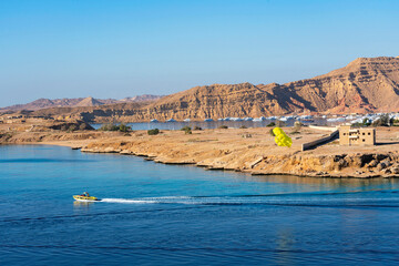 Sharm El-Sheikh, Egypt: yellow parachute with man, flight in blue sky over Red sea, Sinai.