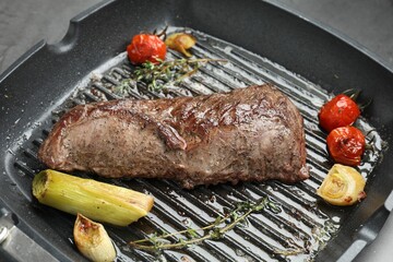 Delicious grilled beef meat and vegetables in pan on table, closeup