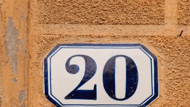 Number 20 (twenty) affixed to the exterior of a building, with an elegant, vintage and traditional appearance