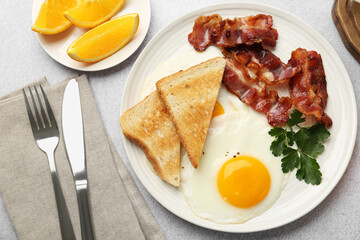 Delicious breakfast with sunny side up egg served on light table, flat lay