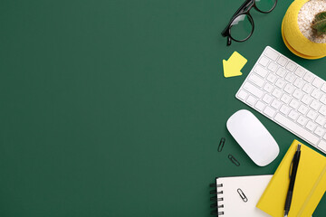 Flat lay composition with different office stationery on green table, space for text