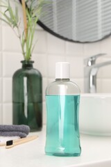 Bottle of mouthwash on white table in bathroom