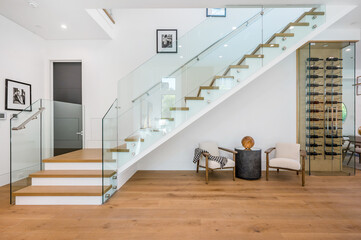 the stairs and glass railings of this modern home have wood and metal