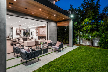 a patio with a large table and chair on it and lots of green grass