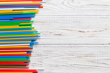 Heap of colorful plastic drinking straws on Colored background, flat lay. Copy Space for text