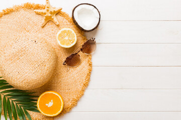 Top view of various seashells placed near colorful fruit and stylish summer accessories on table...