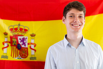 Portrait of positive student against background of flag of Spain. Concept of relocation and...