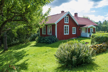 Idyllic red cottage by the forest edge