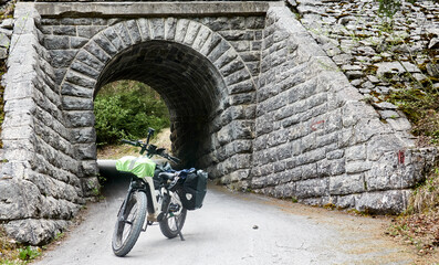 Fatbike parked in front of an underpass made of rough natural stones