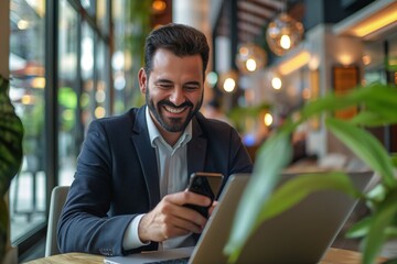 Obraz premium Businessman Smiling at Phone in Restaurant - Professional Man in Suit at Table