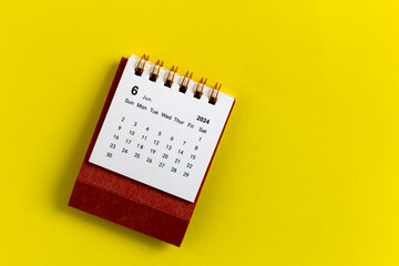 Desk calendar for June 2024 on a yellow background.
