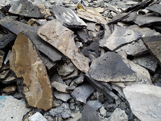 Pile of asphalt rubble from road demolition. Construction debris and broken pavement. Design for poster, banner.