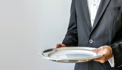 A butler in a formal outfit holding a silver tray with an empty plate, isolated on a white...