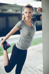 Obraz premium Active young woman working out with headphones outside