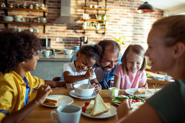 Happy diverse family enjoying breakfast together in a cozy kitchen