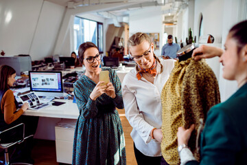 Fashion designers reviewing a clothing sample in a modern studio workspace