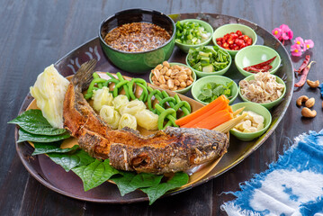 Deep fried fish with various vegetable side dishes and dipping sauces.